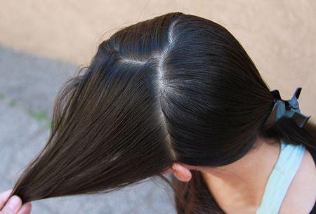 给头发做分区,尖尾梳将头发分作前后两个层次,脑后头发用发夹固定.