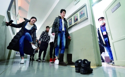表演系考生在考场门前脱鞋准备量身高 摄/记者 郭谦