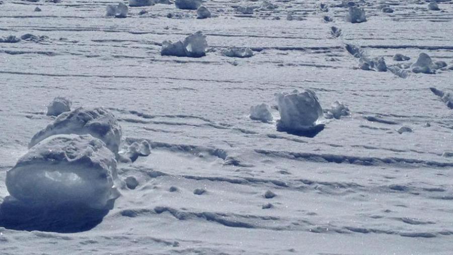 在雪地上好似排列着一团团的棉花糖,仔细观察可发现雪卷中心是空的