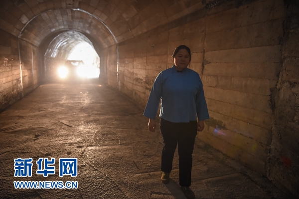 在贵州罗甸县董架乡麻怀村,邓迎香进入她率领村民“刨出来”的人工隧道(2015年12月15日摄)。新华社记者 欧东衢