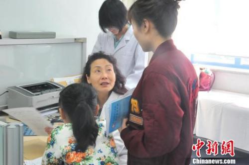 图为巩纯秀与患儿家长交流.吕春荣 摄