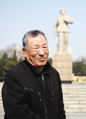 乔安山站在雷锋雕塑前据新华社