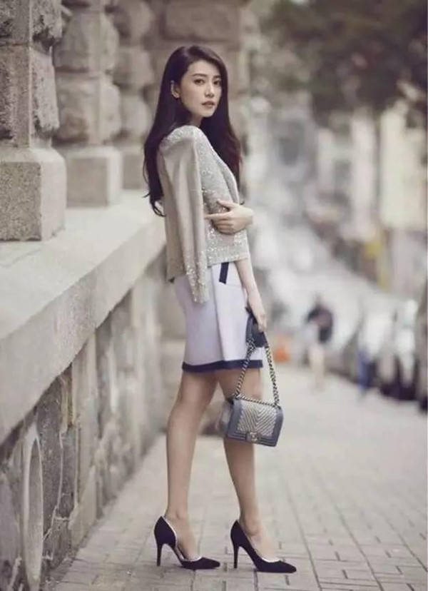 白色连衣裙外搭针织开衫,搭配一双黑色高跟鞋,非常淑女,名媛范十足.