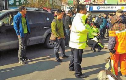 杨学志倒在地上,同事正在照顾他