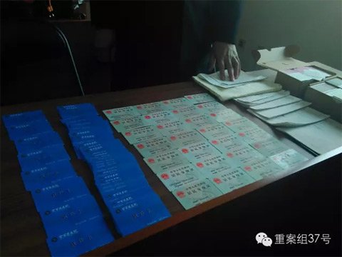 警方展示起獲的涉案物品，包括團(tuán)伙購(gòu)買(mǎi)的他人身份證，用身份證辦理的醫(yī)院就診卡及團(tuán)伙賬本、宣傳卡片等。 劉思維/攝