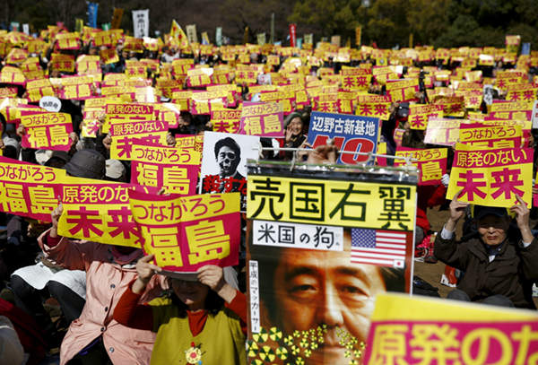 图为日本东京民众举行反核示威,民众举标语斥安倍是美国的狗。