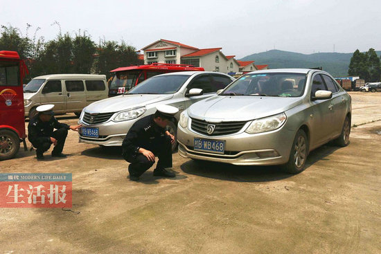 图为民警在查看两辆同一车牌的车子。交警供图