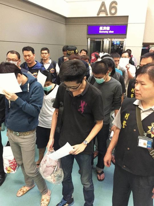 马来西亚警方以违反当地移民法逮捕的20名台湾地区诈骗嫌犯，15日搭全亚洲航空班机于深夜驱逐出境回台。来源：中时电子报