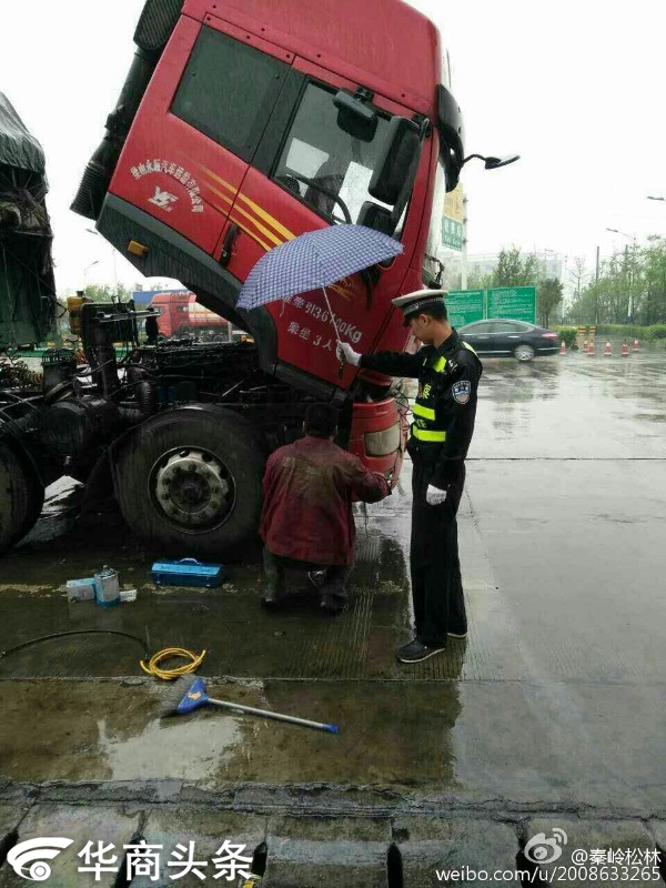 司机雨中修车 渭南交警帮他撑伞(组图)