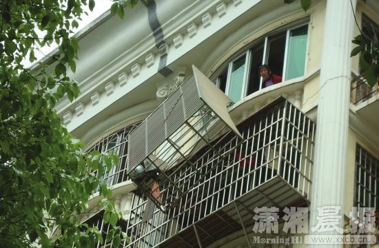 4月15日,长沙中南汽车全球G6栋,离开 墙体的护窗风雨飘摇。图/潇湘晨报记者陈斌