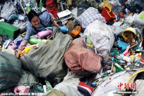 资料图。2015年4月6日,重庆,这是清理工在堆码场将大包的垃圾转运至分拣点,以方便开包处理。 江上鸥 摄 东方IC