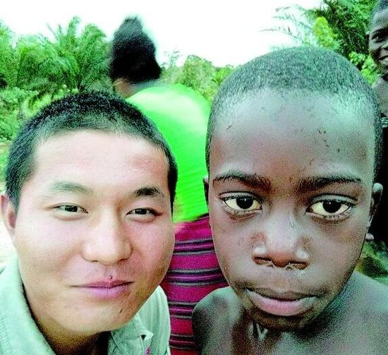 图为:刘明和安哥拉本地小男孩留影刘明和工