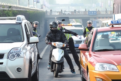 交警早高峰查摩托车1小时25名司机挨罚(图)