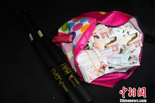 警方在刘某车中搜出的招嫖卡片和棒球棍 朱华刚 摄