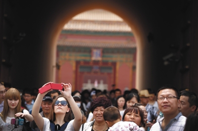昨天,天下各地旅客来到北京玩耍,故宫博物院游人如织,摩肩接踵。图/IC