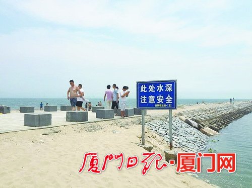 滨海西大道后田海边,“注意安全”警示牌形单影只,不少市民自顾自下水游玩。