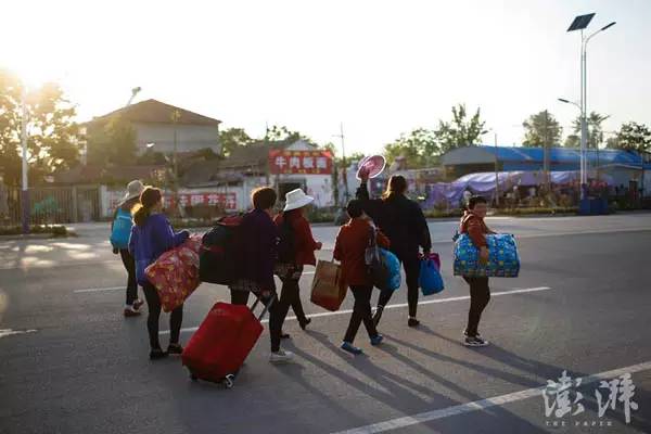 5月15日，山东金乡，7名刚刚抵达的女劳工拖着自己的行李走在大街上。