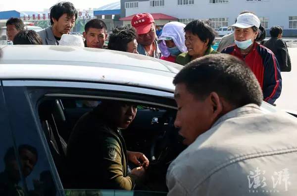 5月19日，金乡劳务市场上，十多名劳工围在蒜农的车旁招揽活计。