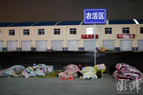 5月19日,山东金乡。劳务市场附近的客栈已经住满,无法住店的劳工在街头露宿。