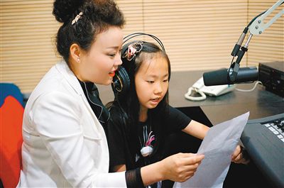 董怡欣和家长一起录制自己的作文。