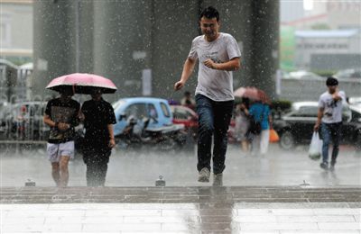 昨日，十里河，一场暴雨突然来袭，没带伞的路人在雨中奔跑。