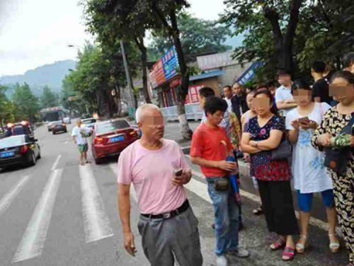 头部有细微血迹的女子在沙坪坝双碑转盘人行横道上拦挡一辆过路车辆索要“过盘费”。