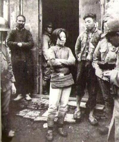 这张照片中的女性还穿着八路军抗日队伍的装束,皮带挂在腰上,裤子上