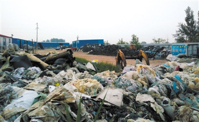 昨日，河北沧州盐山县于庵村，央视报道中涉及的一家橡胶生产企业院子里堆放着蛇皮口袋、废弃轮胎等物品。新京报记者 李强 摄
