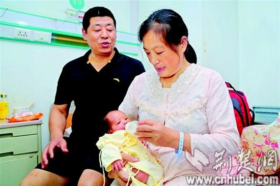 图为：昨日上午10时，51岁的靖明华，把54岁的妻子刘洪梅和刚刚出生7天的儿子欣欣从襄阳市第一人民医院接回了家。