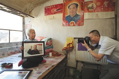 4月24日,延庆展出了450余张老党员照片,摄影师亲自将王老太太的照片送到她的家中。新京报记者 彭子洋 摄