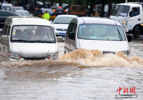 7月4日，暴雨致江西九江城区部分路段出现内涝现象，市民开车如“开船”。 胡国林 摄