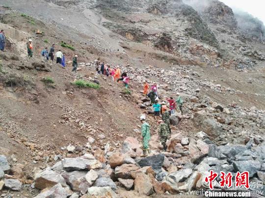 图为丽宁公路部分路段发生塌方,救援人员转移被困民众。 丽江市委宣传部官方微博 摄