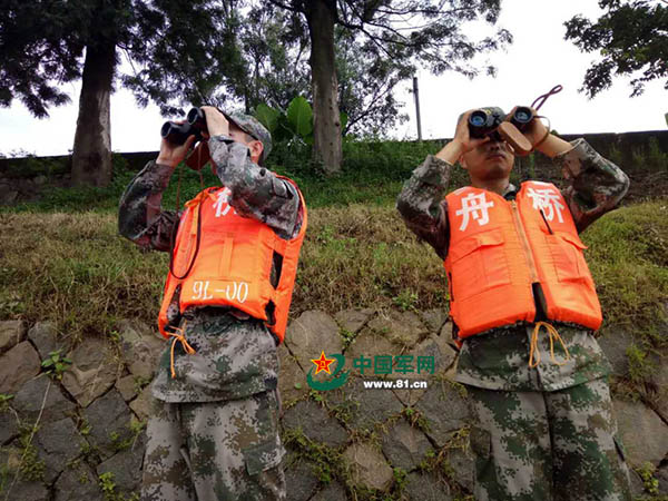 在岸上的士兵用千里镜搜查江面。 国家军网 图