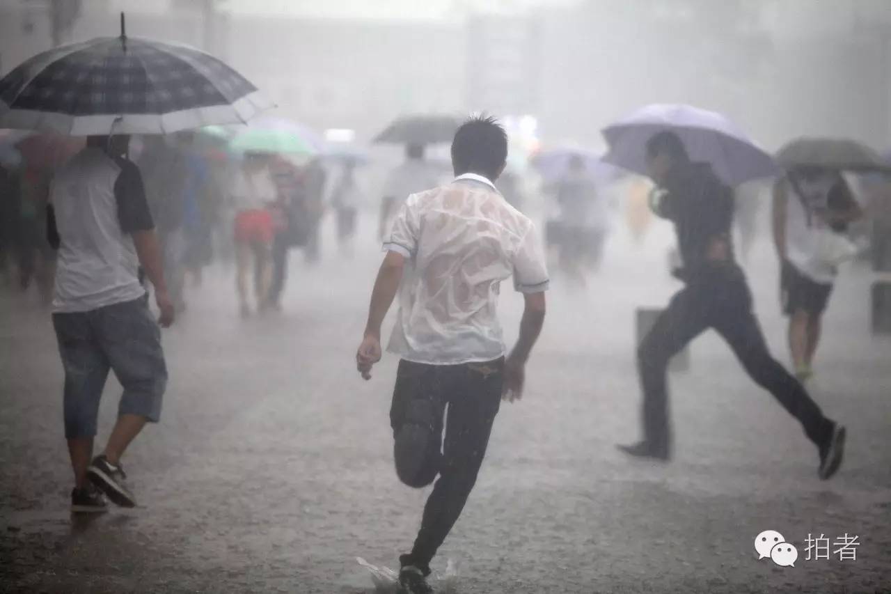 2012年7月21日,北京火车站广场,正在雨中奔跑的人们.