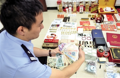 昨天,南岸公循分局,警朴直在盘点29岁“金领男”田某行窃的奢华品。 本报记者 李斌 摄