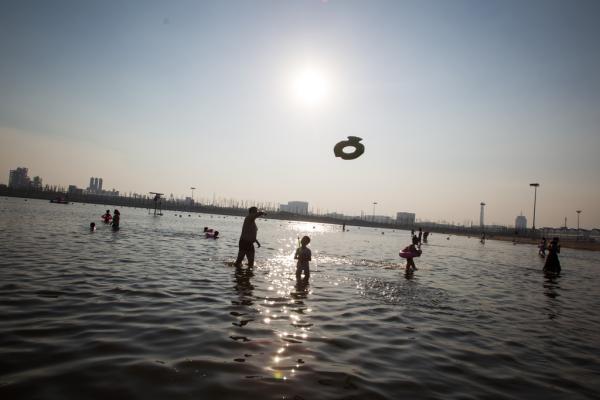 2016年7月22日，上海金山城市沙滩，市民在到海边消暑。 澎湃见习记者 韦毅 图