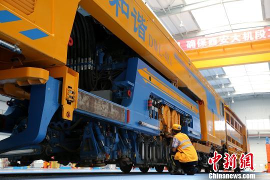 图为工人正在清理大型养路机械 张远 摄