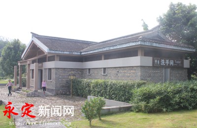 永定新闻网报道 8月9日，笔者在福建土楼永定洪坑景区游客服务中心看到，一旁的公厕清新亮丽：卫生整洁，空气清新，标识规范的厕所，伴有柔和的背景音乐，还设有休息厅、母婴室、寄存室、管理房、第三卫生间等功能区室。公厕入口处，穿着保洁服装的保洁员笑容可亲的接待八方游客。