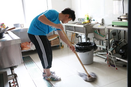 队员俞康康在厨房打扫