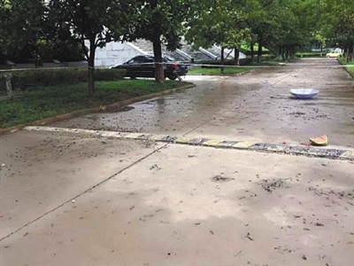 校园中事发道路上，一把雨伞躺在地上，现场被封锁。家属供图