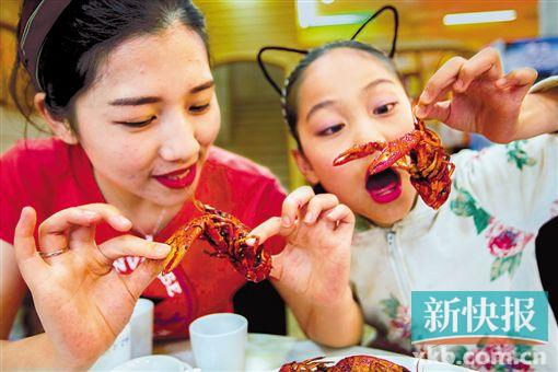 旅客在“龙虾之乡”江苏省盱眙县一饭馆品味小龙虾。新华社发