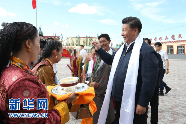 这是8月22日下午，习近平在海西蒙古族藏族自治州格尔木市唐古拉山镇长江源村考察时接受村民献上的青稞酒。 新华社记者 庞兴雷