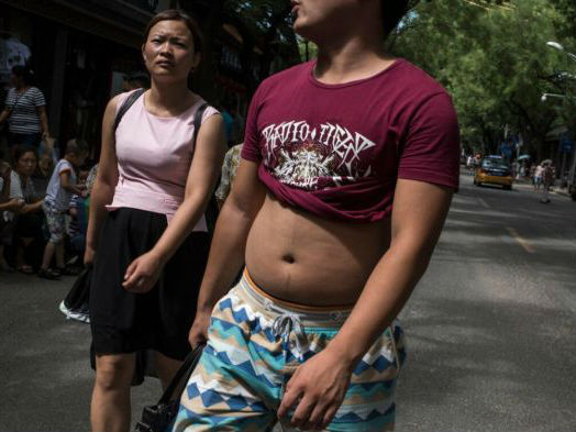 在中国,男性可以任意捲起上衣,但女性则不被鼓励以同样方式露出身体。(图片来源:美国《纽约时报》网站)
