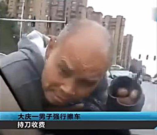 黑龙江一男子持刀擦车被行拘,自称为索要2元买酒钱。视频截图