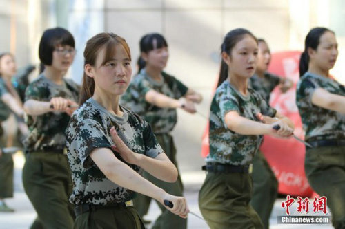 操场上,姑娘们手中紧握约15厘米长的橡胶制“匕首”,“哈!”伴随着一声清亮的口号,她们右脚原地用力下踏,左脚向右大跨弓步的同时迅速向左转身,左臂向上化掌格挡在胸前,持匕首的右手挥刀猛力向前刺出。129人的队列动作整齐划一,她们昂头收颌,目视前方,眼神坚定,英气十足。
