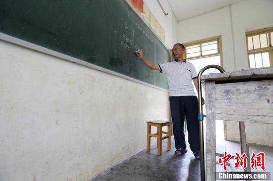在广西柳州市融安县东起乡的偏僻山坳里,有一所“微小学”——东起乡长丰村小学,2016年秋季学期,这里只有12名学生和一名叫李朝文的老师。李老师年过五十且腿部有残疾,执教38年来,他默默坚守在三尺讲台上,守护着大山里的孩子,被当地人誉为“最美乡村教师”。1986年,李朝文老师在学生家访途中腿部摔伤,落下残疾。在腿部受伤后,李朝文拄着拐杖一直坚守在三尺讲台上,至今已经第30个年头。近年来,随着村民外出人数增多,这里上学的孩子也越来越少,老师们也陆续离开,李朝文却一直坚守在这里,独自一人担负起给孩子们教授语文、数学、音乐等6门课程的重任,风雨无阻。他教过的学生,有超过100名学生考上县里或市里的重点高中,有的还考上清华等名牌大学,走出了大山。谭凯兴 摄