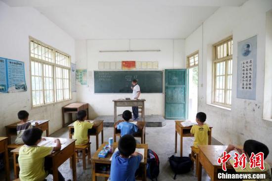 9月9日,在广西柳州市融安县东起乡长丰小学,李朝文在给学生上数学课。谭凯兴 摄