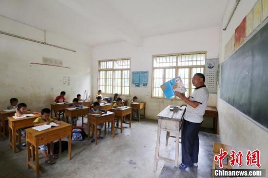 9月9日,在广西柳州市融安县东起乡长丰小学,学生们在听李朝文讲课。谭凯兴 摄