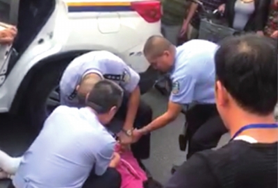 女子赖地不起，后被民警控制。视频截图