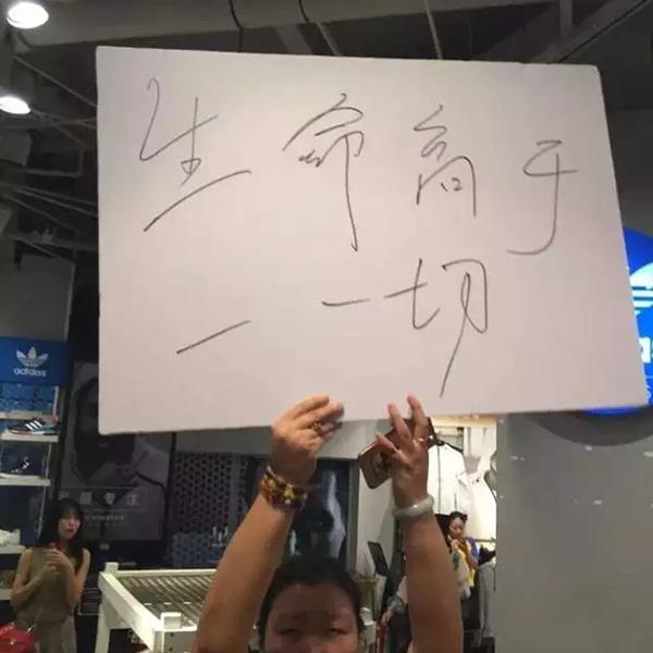 商场工作人员高举牌子。